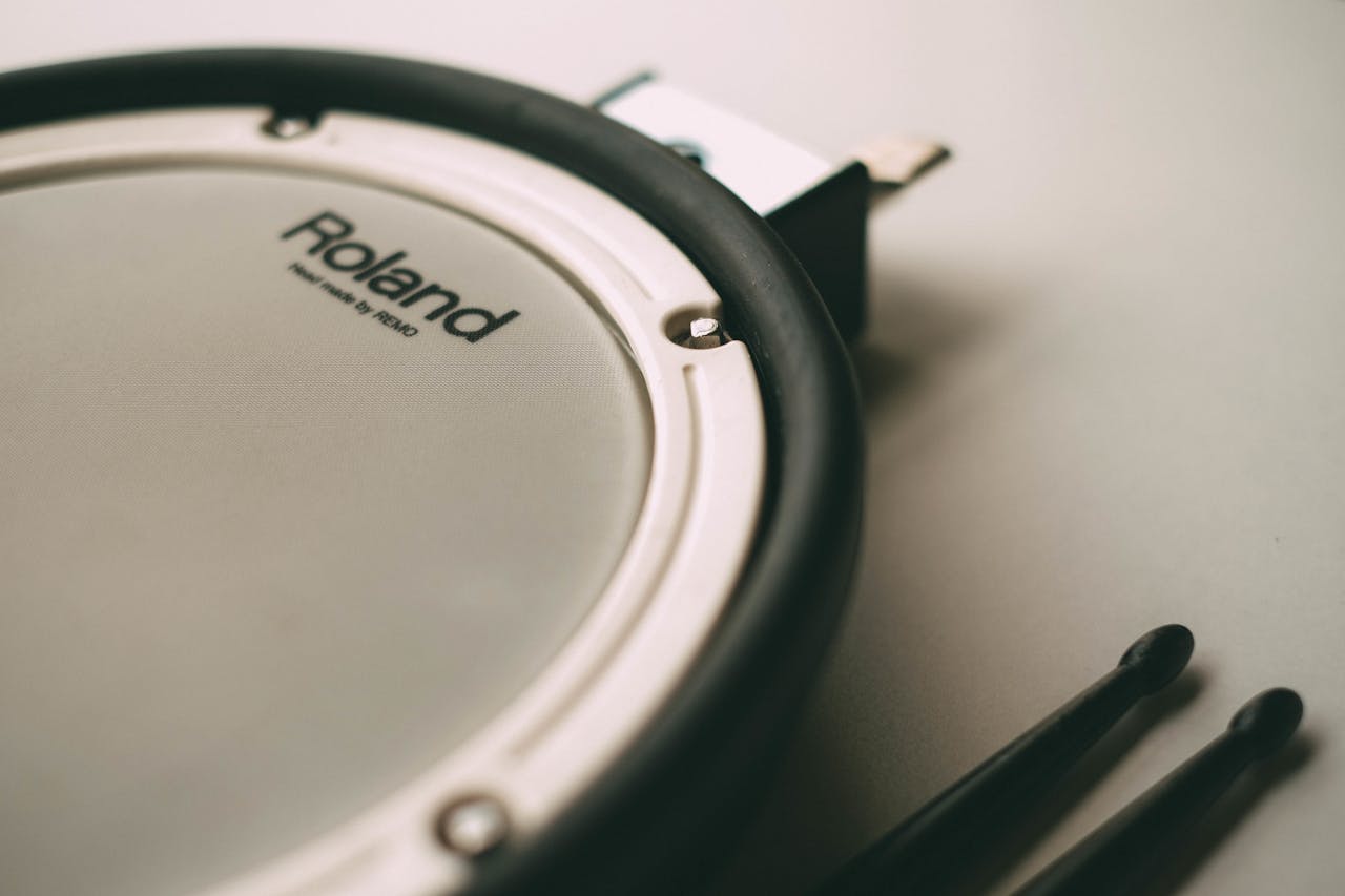 Detailed shot of a Roland electronic drum pad with drumsticks emphasizing percussion elements.